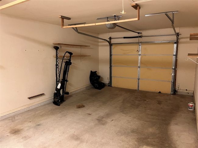 Garage with a garage door opener and baseboards | Image 11