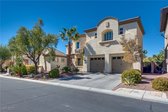 Mediterranean / spanish home with driveway, a gate, stucco siding, an attached garage, and a tiled roof | Image 5