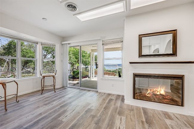 From the arched doorway off of the living area, enjoy the decorative electric fireplace, large dining area and access from the sliding glass doors. | Image 11