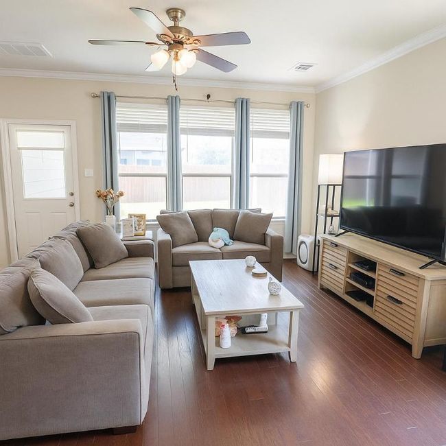 Living area with ceiling fan, dark wood-style floors, and crown molding | Image 6