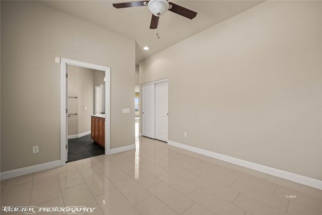 Unfurnished bedroom with recessed lighting, light tile patterned floors, baseboards, and connected bathroom | Image 35