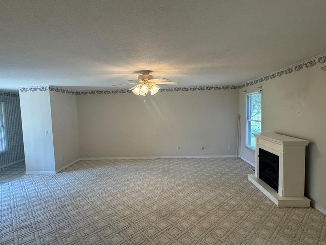 Unfurnished living room featuring ceiling fan and a textured ceiling | Image 8