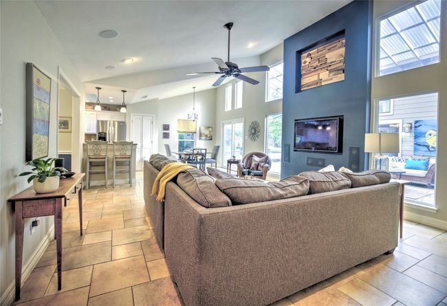 Open living Room with high ceilings, recessed lighting, ceiling fan and view into courtyard | Image 5