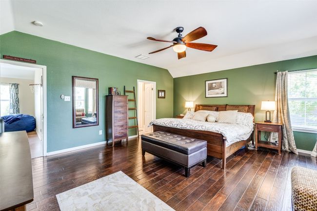 Bedroom featuring vaulted ceiling, wood finished floors, baseboards, and a ceiling fan | Image 12