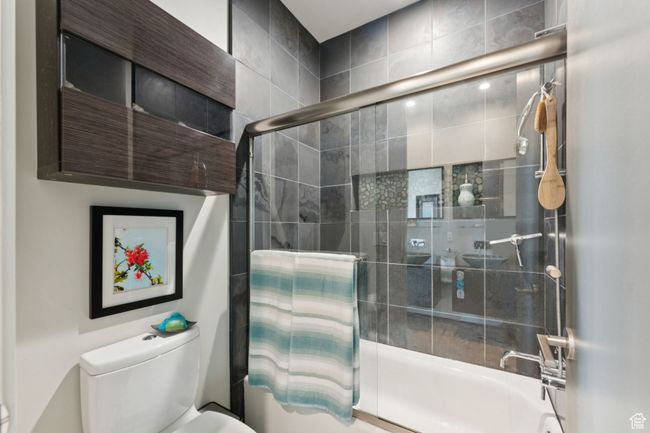 Bathroom with toilet and shower / bath combination with glass door | Image 27