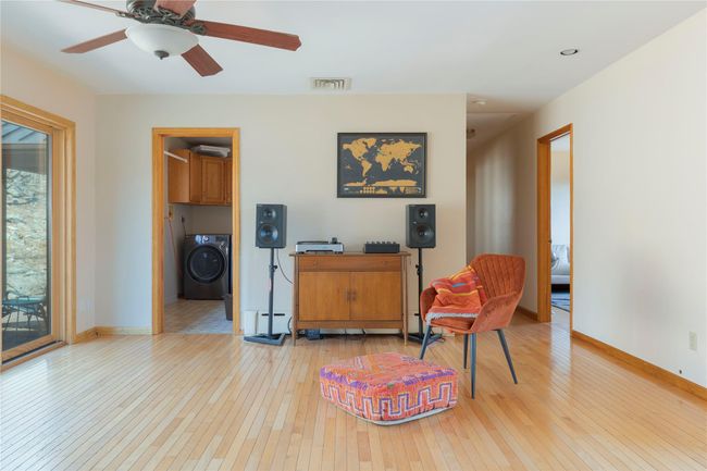 Living area featuring wood-type flooring, washer / clothes dryer, baseboards, and visible vents | Image 13