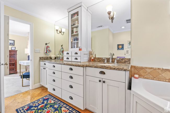 Bathroom featuring ornamental molding, visible vents, vanity, and a bath | Image 28