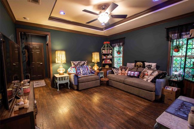 Second Living room featuring a raised ceiling, crown molding, ceiling fan, and wood finished floors | Image 17