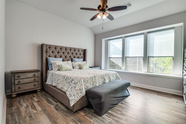 Bedroom featuring multiple windows, lofted ceiling, dark wood-type flooring, and a ceiling fan | Image 15