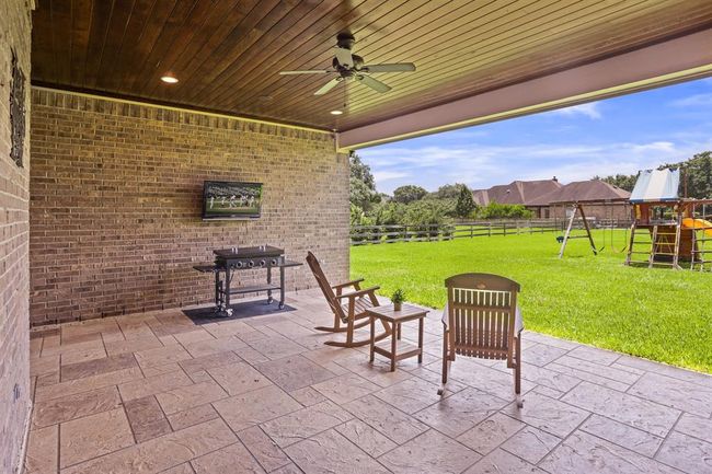 This Backyard Patio is grand in both size and function. The low maintenance floors keep the space slip-free and easy to wash down. The wood paneled ceiling mimics the one found in the Foyer and Living Room, continuing that attention to detail and consistency. | Image 40