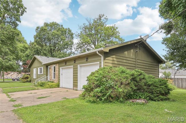 View of side of property with driveway, a garage, and a lawn | Image 27