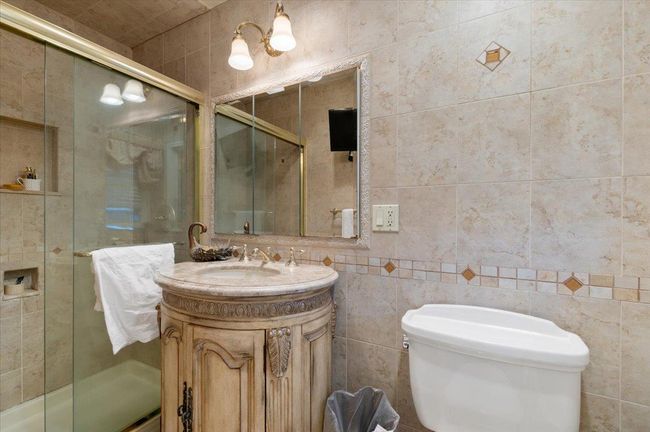 Bathroom with vanity, a stall shower, toilet, and tile walls | Image 15
