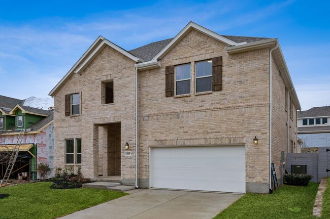 View of front of property featuring an attached garage, driveway, a front yard, and brick siding | Image 37