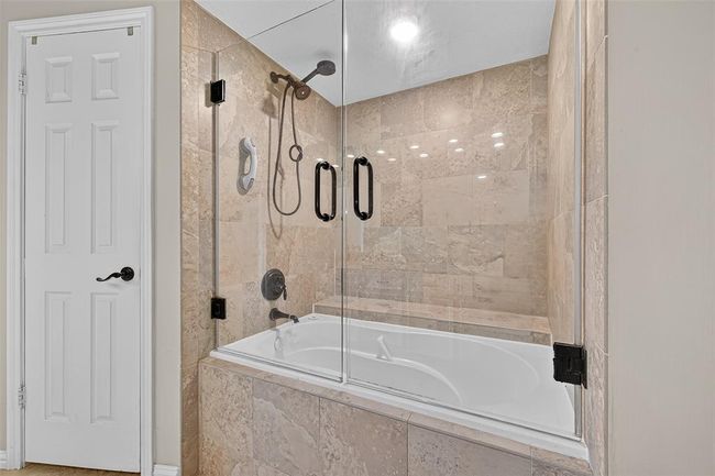 The enclosed tub and shower area continues the thoughtful tone, with understated detailing and a fresh finish. | Image 41