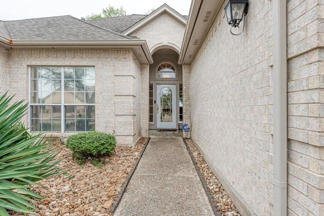 Entrance to property with a shingled roof and brick siding | Image 9