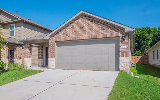 View of front facade with brick siding, stone siding, and driveway | Image 21