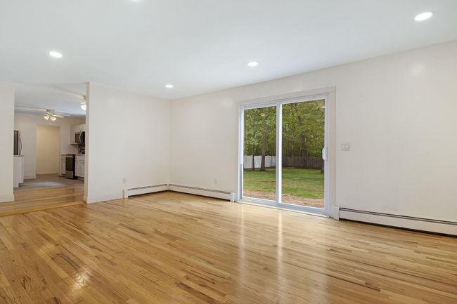 Empty room with light wood-type flooring, a ceiling fan, recessed lighting, and baseboard heating | Image 9