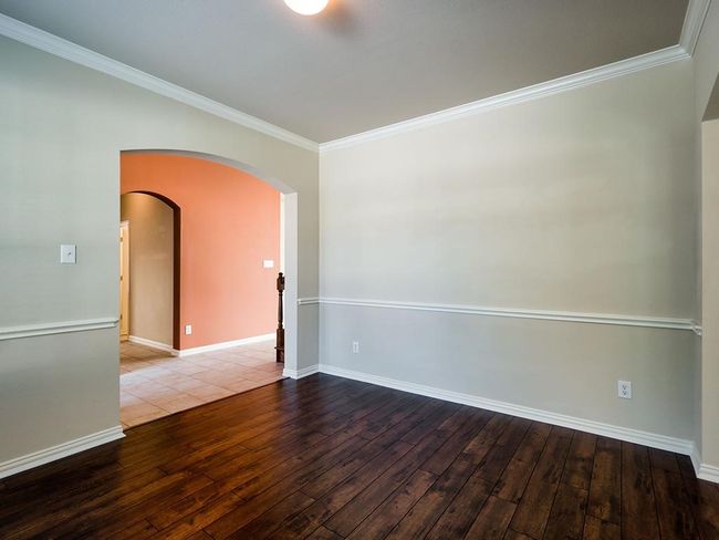 Spare room featuring hardwood / wood-style floors, arched walkways, ornamental molding, and baseboards | Image 10