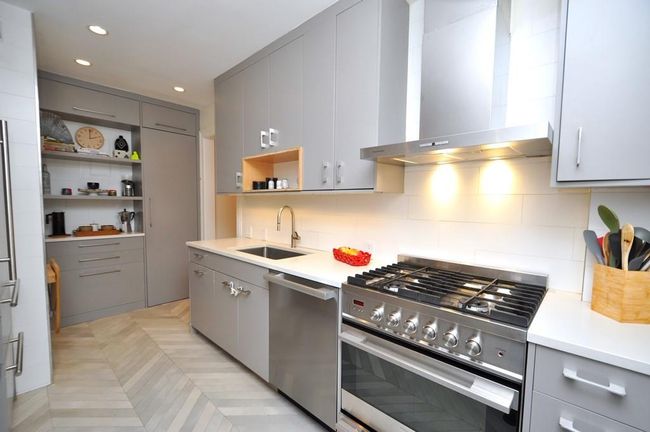 Renovated kitchen has custom cabinets, stainless steel appliances including a stove, dishwasher and steam oven. The refrigerator has matching cabinet door. Other features include a quartz counter, pantry, walk-in closet, under cabinets lighting and herringbone tile floor. | Image 8