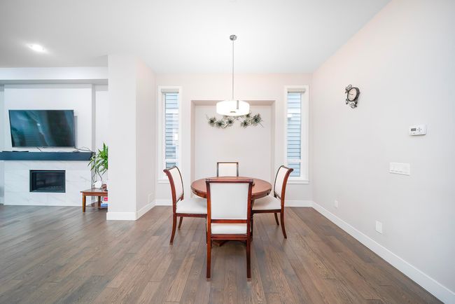 Dining space with dark wood-style flooring, healthy amount of natural light, and baseboards | Image 5