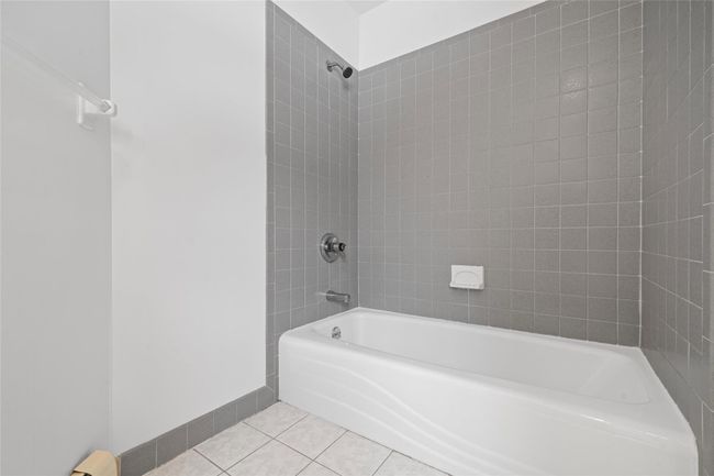 Bathroom featuring baseboards, tile patterned flooring, and shower / bathing tub combination | Image 34