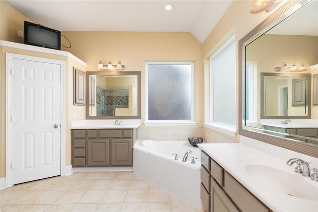 Start and end your day in this serene, well-appointed retreat. Soak in the jetted tub after a long day or enjoy the spacious, glass-enclosed shower in the morning light. With generous storage and dual vanities, there’s room for everything without ever feeling crowded. | Image 16