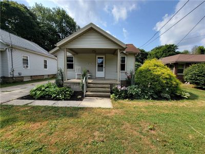 Bungalow-style house with a porch and a front lawn | Image 1