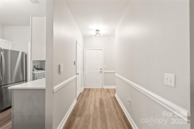 Open hall has guest room and office when you enter and leads into living area. | Image 16