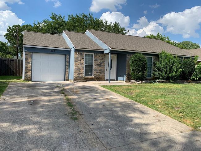 Ranch-style house with a garage and a front yard | Image 1