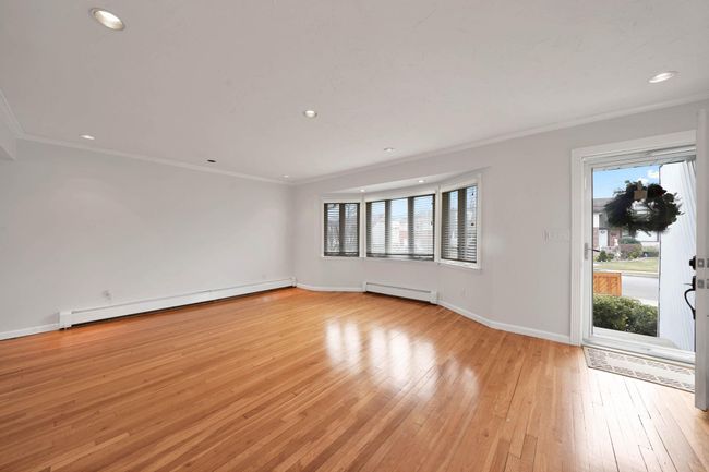 Empty room featuring light hardwood / wood-style floors, baseboard heating, and crown molding | Image 4