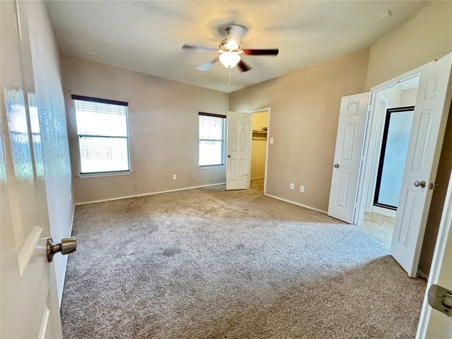 Unfurnished bedroom with carpet floors, ceiling fan, and a spacious closet | Image 11