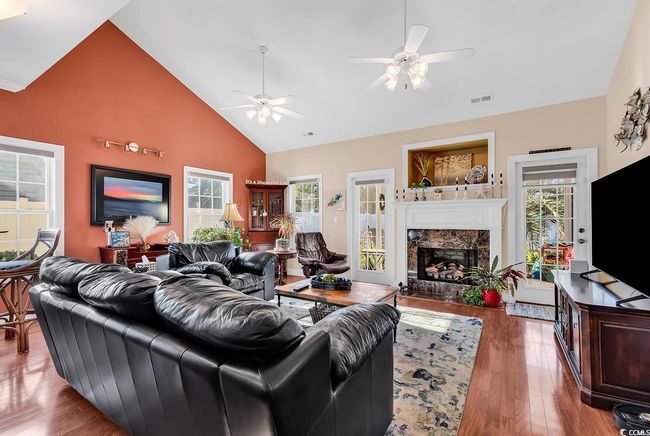 Living room featuring hardwood / wood-style flooring, a premium fireplace, high vaulted ceiling, and ceiling fan | Image 15