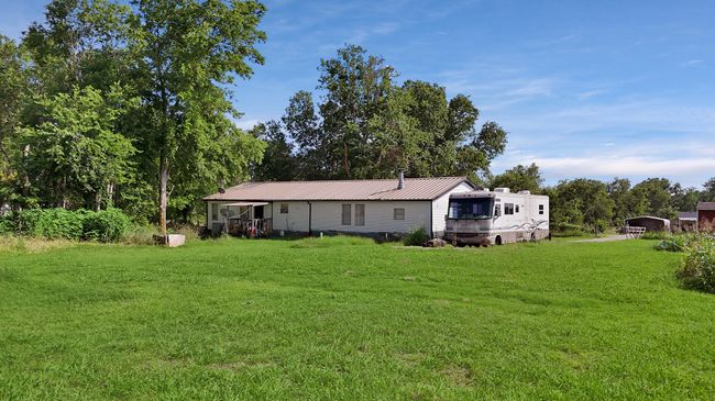 Rear view of property featuring a yard and a metal roof | Image 13