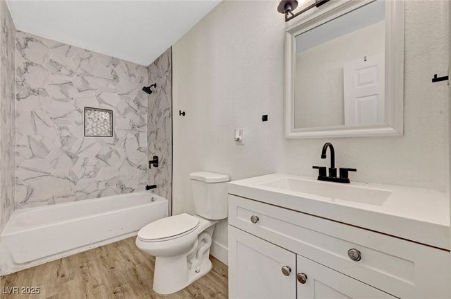 Bathroom with wood finished floors, vanity, and bathing tub / shower combination | Image 18