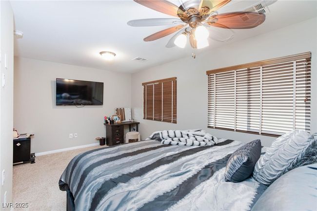 Carpeted bedroom with ceiling fan, baseboards, and visible vents | Image 32