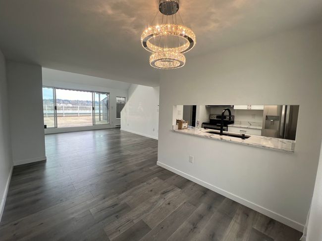 Living room with a chandelier and dark wood finished floors | Image 9