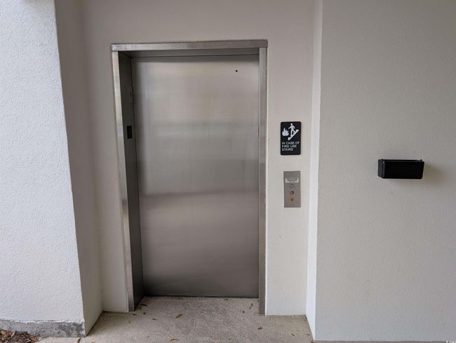 Property entrance with elevator and stucco siding | Image 17