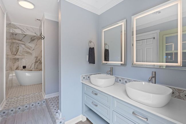 Bathroom with crown molding, double vanity, and a soaking tub | Image 24