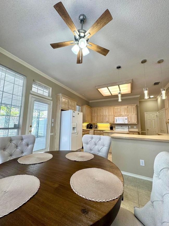 Dining room featuring crown molding, visible vents, a ceiling fan, and a textured ceiling | Image 13