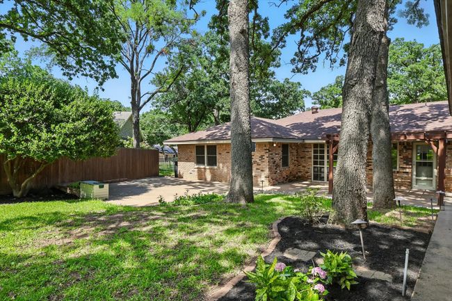 Rear view of property with brick siding, a patio area, and a shingled roof | Image 31