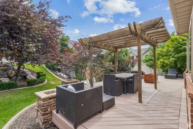 Wooden deck featuring a pergola and outdoor dining space | Image 77