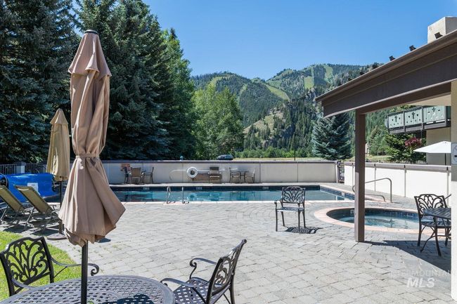 Community pool featuring a mountain view, a hot tub, and a patio area | Image 20