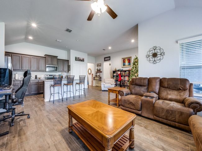 Living room featuring lofted ceiling, ceiling fan, light wood-style floors, recessed lighting, and a desk | Image 13