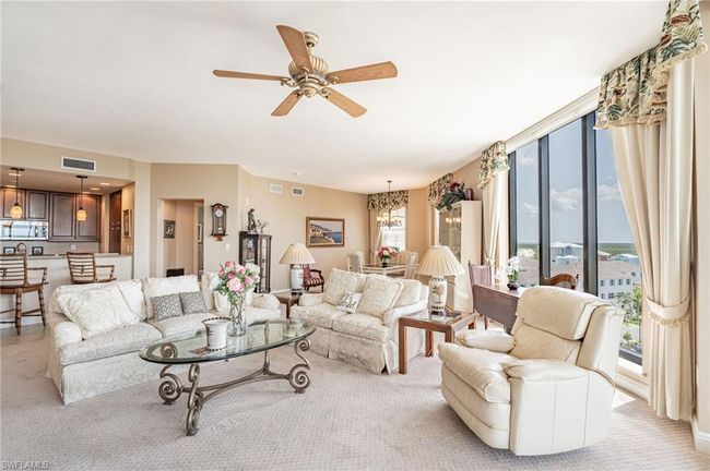Living room featuring ceiling fan with notable chandelier and light colored carpet | Image 15