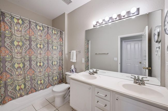 Hall Bathroom featuring tile floors, double vanity, toilet, and shower / tub combo | Image 15