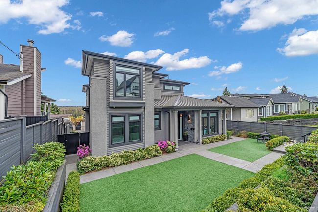 Back of property featuring a lawn, a fenced backyard, metal roof, stucco siding, and a residential view | Image 5