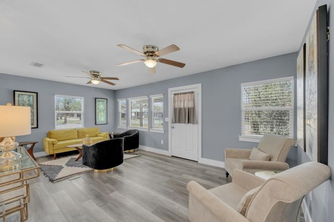 Living area featuring baseboards, visible vents, ceiling fan, and wood finished floors | Image 8