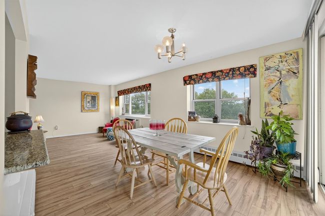 Dining space featuring a chandelier, light wood-type flooring, and a baseboard radiator | Image 15