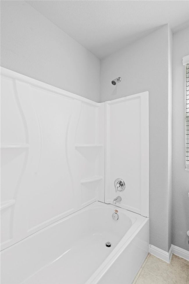 Full bathroom featuring washtub / shower combination and tile patterned floors | Image 28