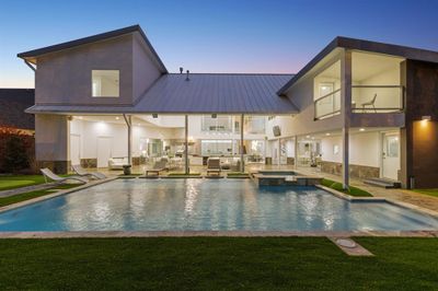 Pool at dusk with an in ground hot tub, a lawn, and a patio | Image 2